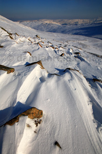 Sculpted snow and ice, Swirral Edge, Helvellyn with High Street glowing in the distance, Lake District