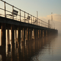 Sun breaking through morning mist at Pooley Bridge Old Pier, Ullswater in winter