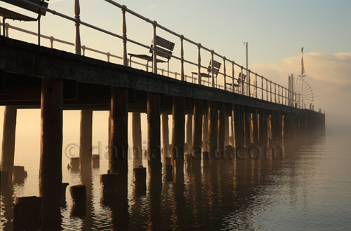 Sun breaking through morning mist at Pooley Bridge Pier, Ullswater in winter