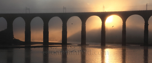 Royal Border Bridge, Berwick-Upon-Tweed with shafts of evening sunlight through mist (sea fret)