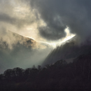 View of The Raise with light breaking through Sticks Pass in the Glencoyne valley, taken from the new pier near Arra Force, Ullswater, Cumbria