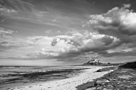 Bamburgh castle and beach with sun and dramatic clouds