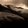 Dramatic image of Blencathra or Saddleback with Halls Fell Ridge and crags lit by evening sun, with rest of mountain in shadow
