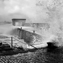 Dramatic wave spash inside Craster Harbour on stormy day in March 2019