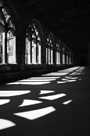 Sunlight pouring through cloisters of Durham Cathedral producing strong shadows of the tracery on stone walkway