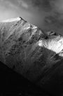 Black and white image of light falling on snow on Hallsfell top and Halls Fell Ridge, Blencathra in the north of the Lake District
