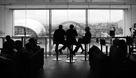 Black and white image of three people sitting in window of Six Rooftop Restaurant at the Baltic Centre overlooking the River Tyne and Newcastle