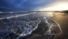 Sun setting over sea and sand of Alnmouth Bay, Northumberland