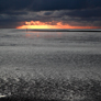 Sunset across Ring Sands, Morecambe Bay, looking towards Heysham wind turbines on horizon